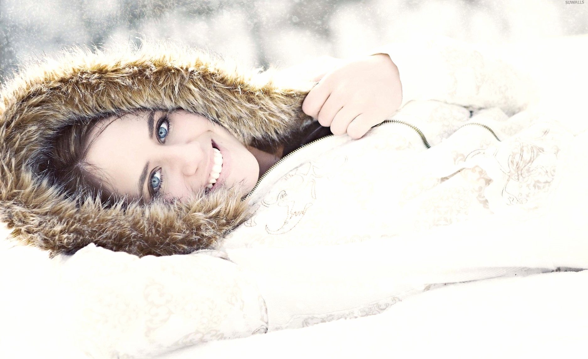 Girl with blue eyes lying in the snow at 640 x 960 iPhone 4 size wallpapers HD quality
