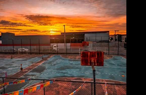 A basketball court with a sunrise in the background