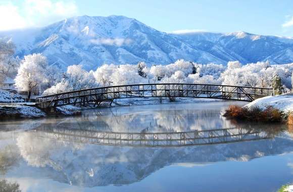 Winter Reflection of Snowy Mountains and Tranquil Bridge